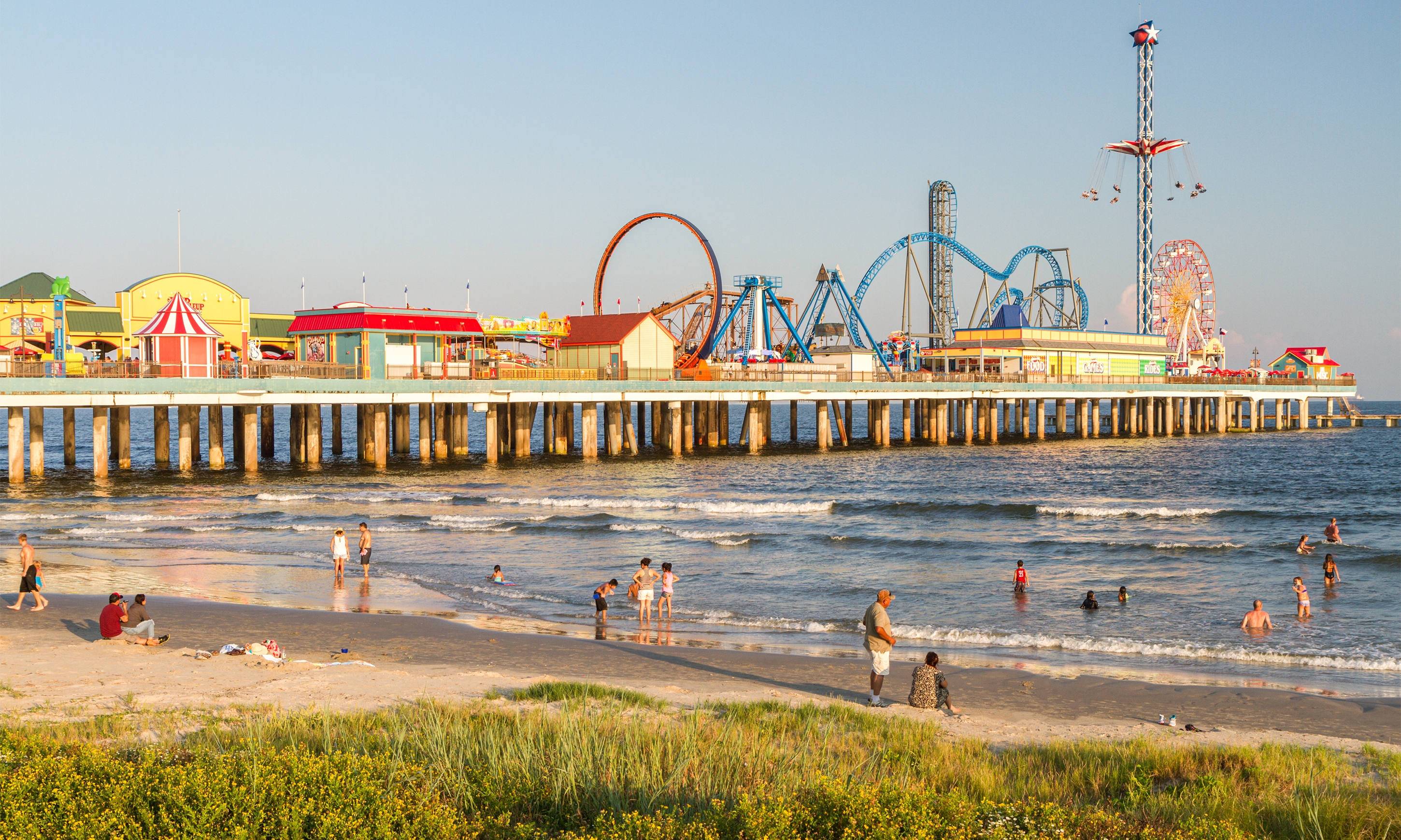 Wooden fishing piers stretching out over Galveston Bay in Kemah, Texas,  USA. Foot pier for saltwater fishing of vacation home/beach house  rental/bay home in Lighthouse District waterfront at sunset Photos