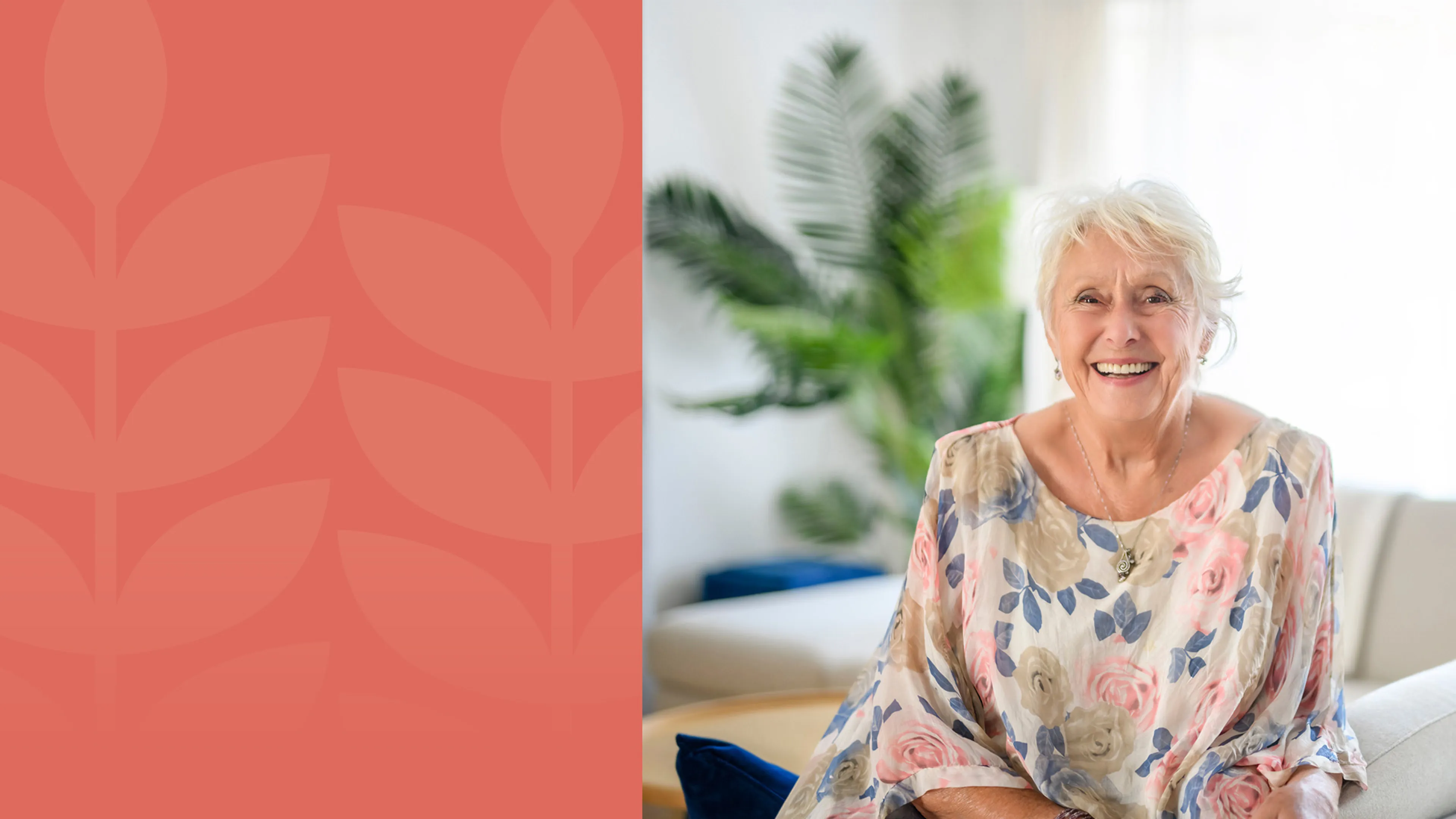 A happy woman is sitting on a couch, smiling at the camera