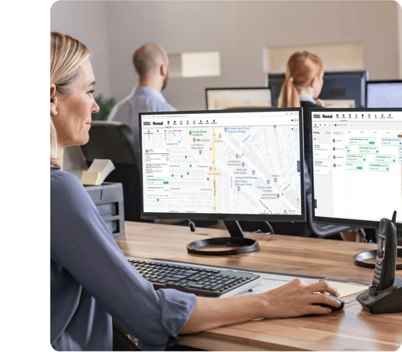 Dispatcher monitoring fleet on dual computer screens.