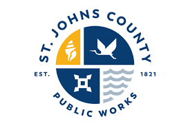 St. Johns County Public Works emblem with four quadrants: a conch shell, a white heron, a four-pronged icon, and wavy lines.
