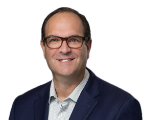 Headshot of a man in a blue suit and glasses.
