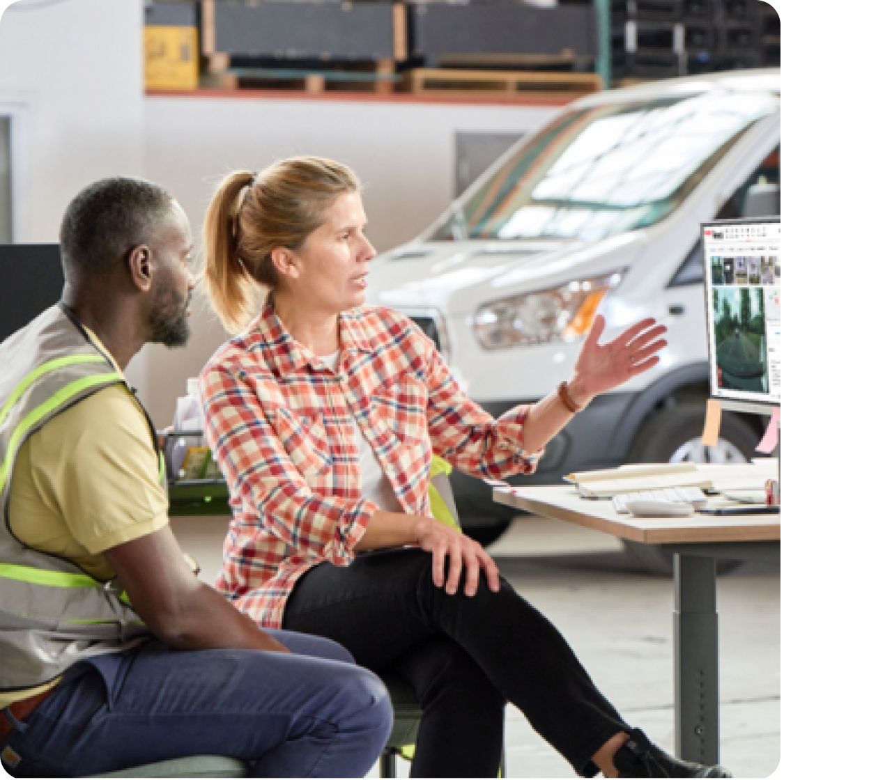 Manager coaching a driver using a computer screen.