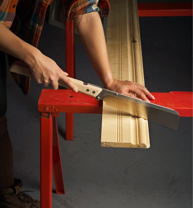 Utilisation d'une scie dozuki pliante pour couper une plinthe