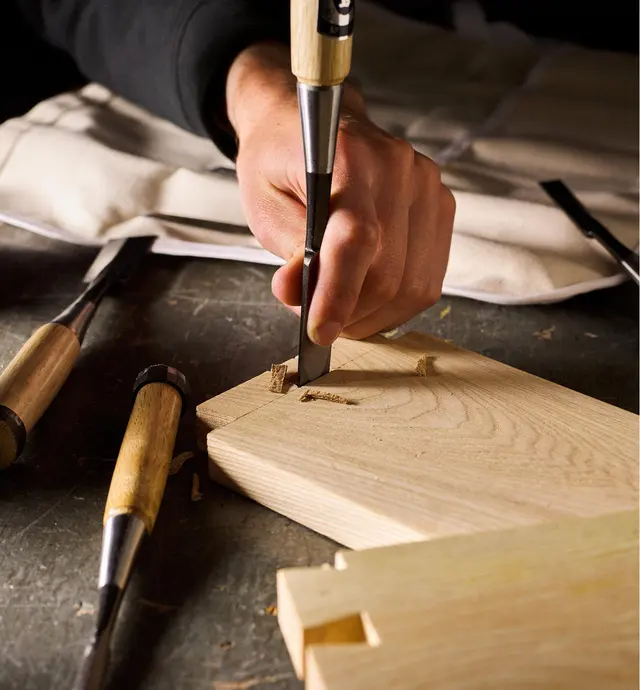 Using a Japanese dovetail chisel to chop out the waste between the pins of a dovetail joint