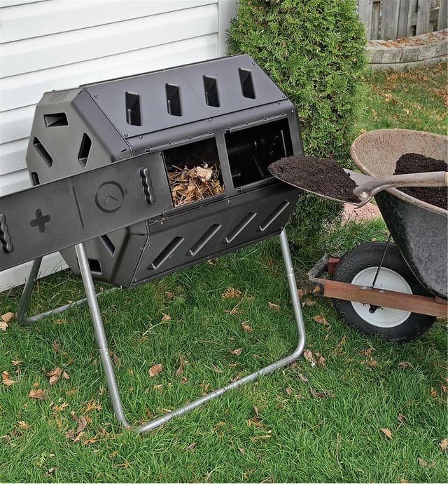 Composteur au couvercle ouvert avec résidus de jardin dans un compartiment et personne retirant du compost de l'autre compartiment avec une pelle