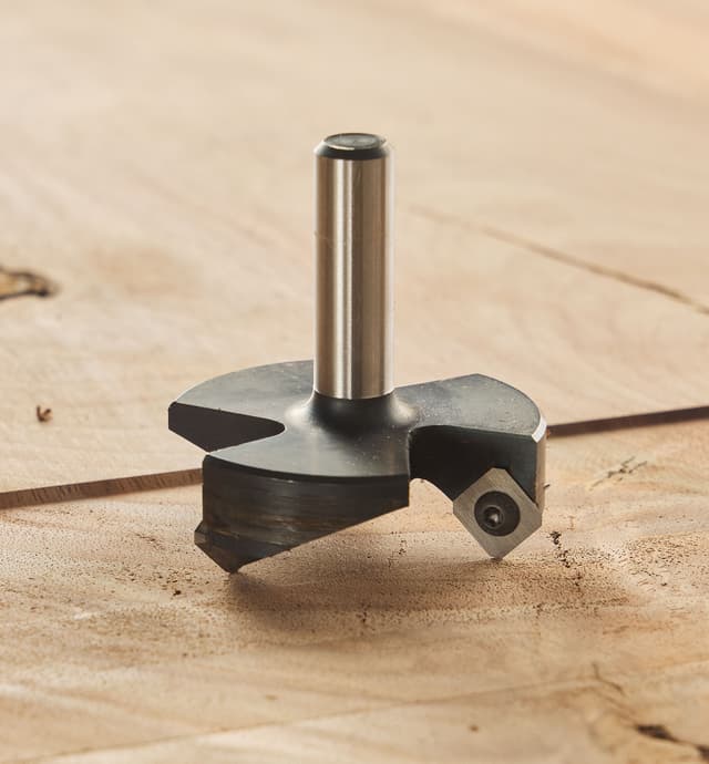 A 2 1/2" slab-flattening router bit placed on a large wooden slab that has been partially flattened