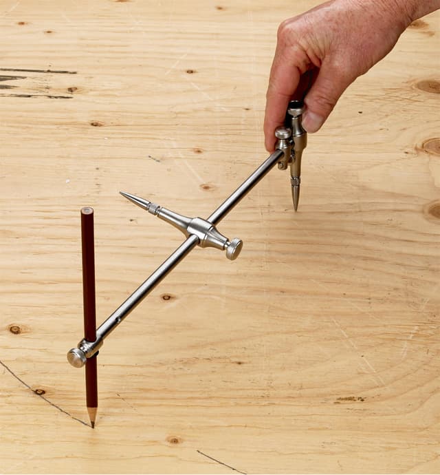 Drawing a circle on wood with a pencil in the beam compass