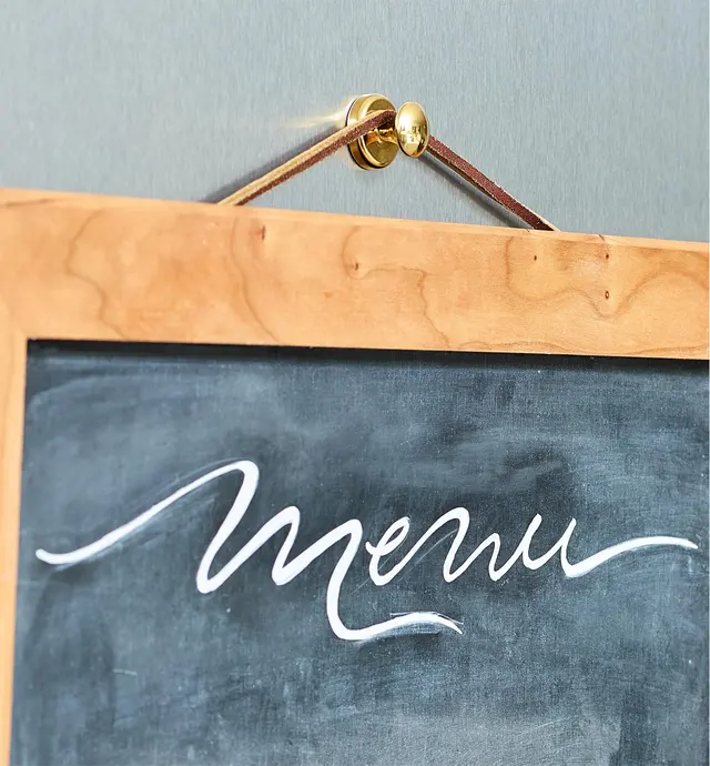A menu board hangs from a hanger knob for steel doors