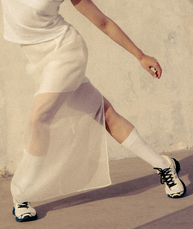 Woman dancing in white wearing ASICS Sportstyle Gel Cumulus 16