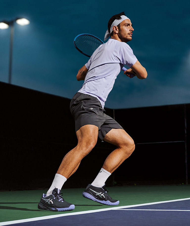 Lorenzo Musetti playing tennis in ASICS Night Energy Collection