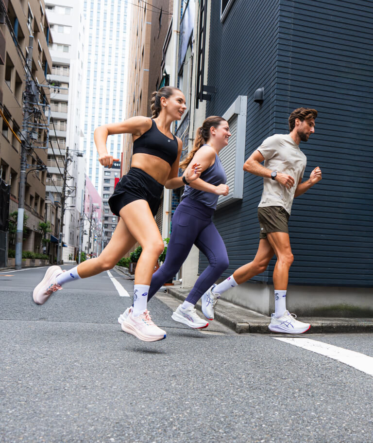 Three people running on a road