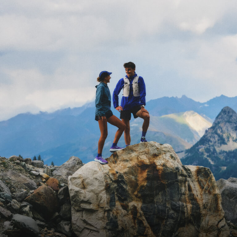 Runners stading on a mountain in ASICS Fujitrail gear