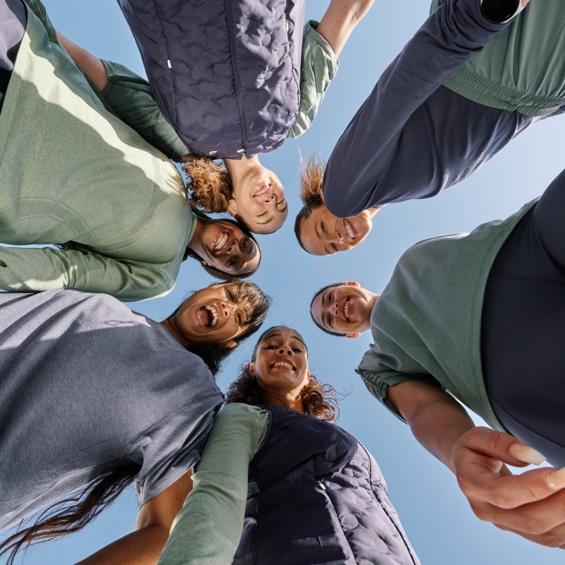 Women standing in a circle looking down into the camera wearing the nagino collection