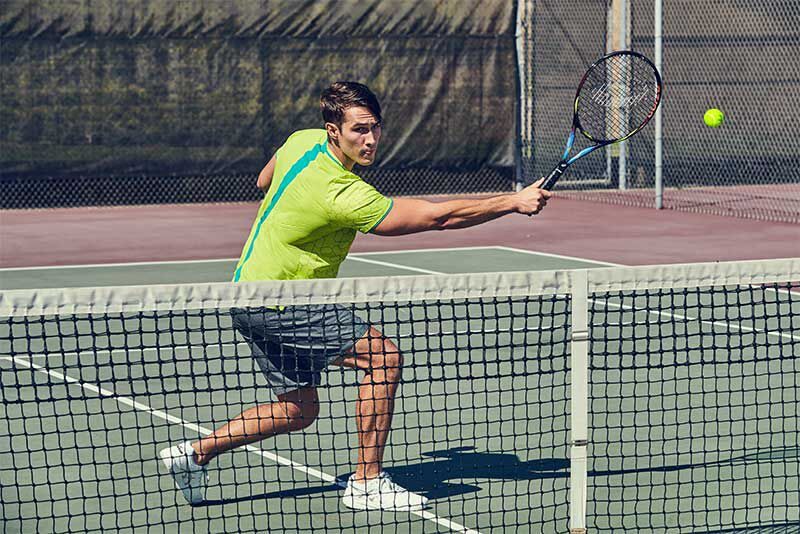 A tennis player outdoors holding a tennis racket
