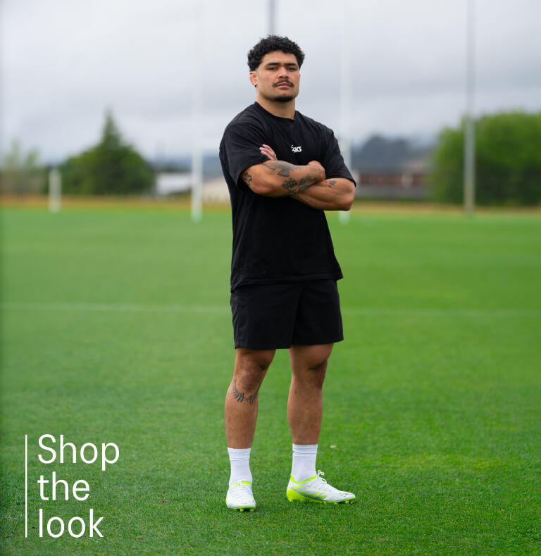 Rugby player wearing black ASICS clothing and rugby boots