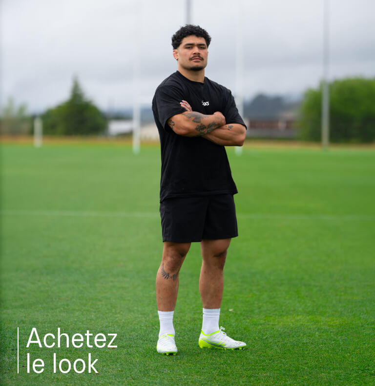 Rugby player wearing black ASICS clothing and rugby boots