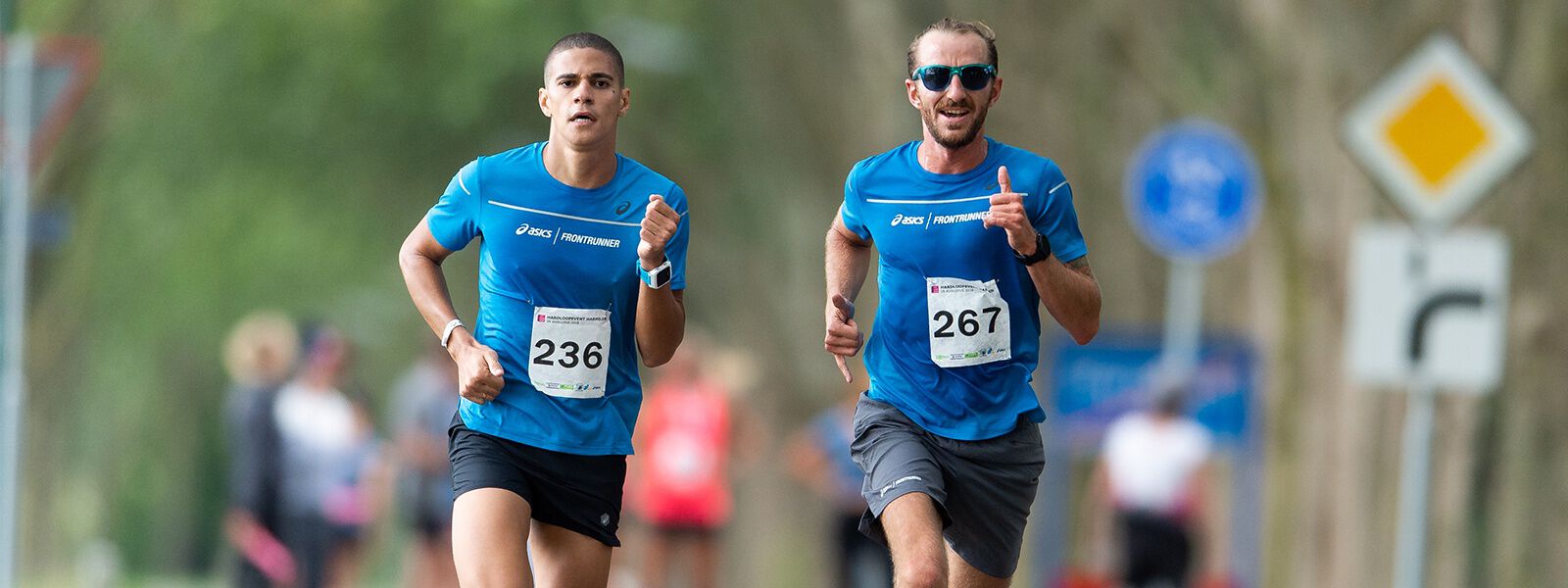 Two runners in ASICS clothing running