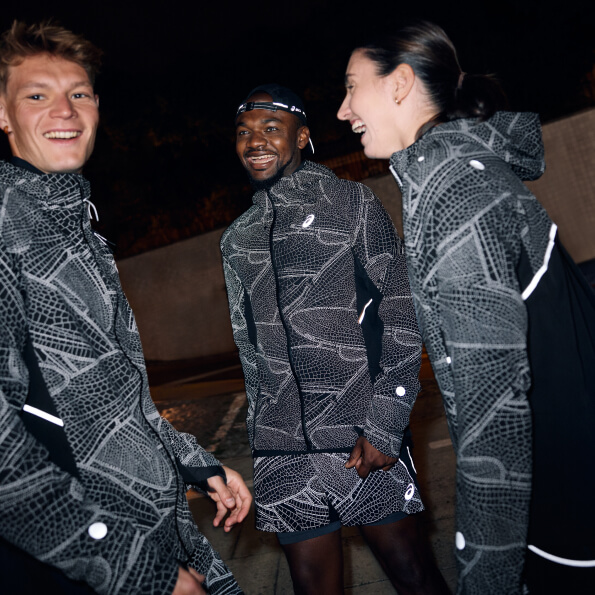 Three runners smiling at each other after a run at night wearing limited series reflective running apparel.