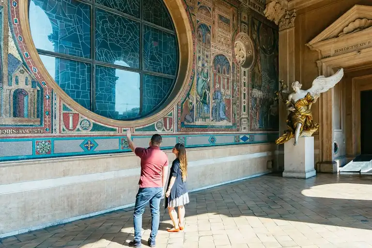 Couple in front of the round big window at Basilica Papale, Rome