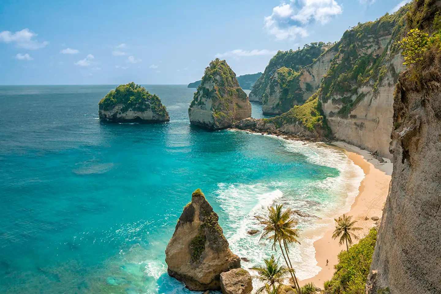 Widok na tropikalną plażę i bujną zieleń na Bali, symbolizujący wakacyjny budżet