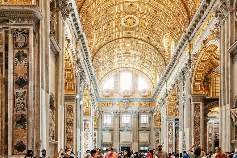 A group of tourists listening to the tour guide inside the St. Peters Basilica