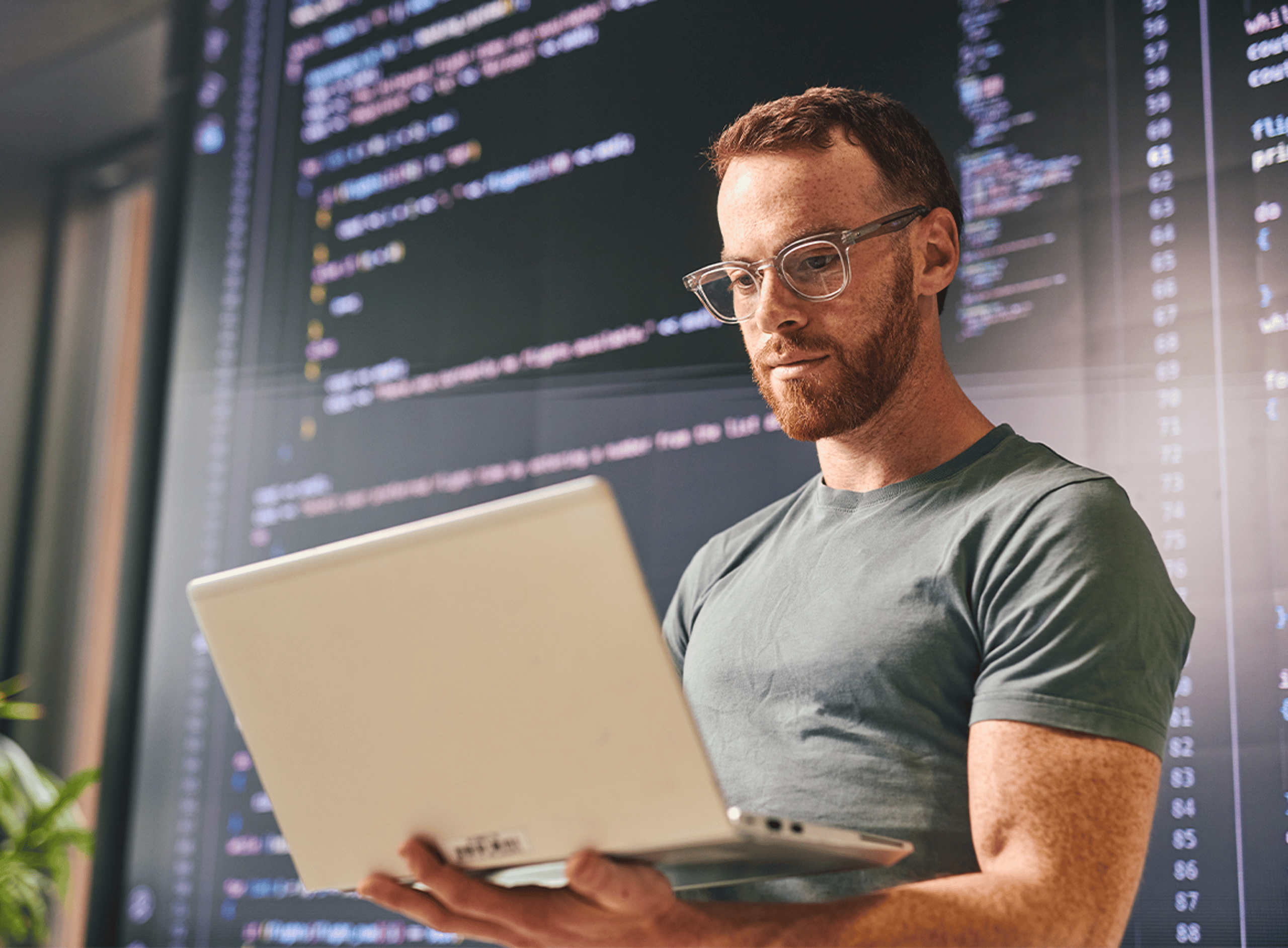 Male laptop software developer code in background