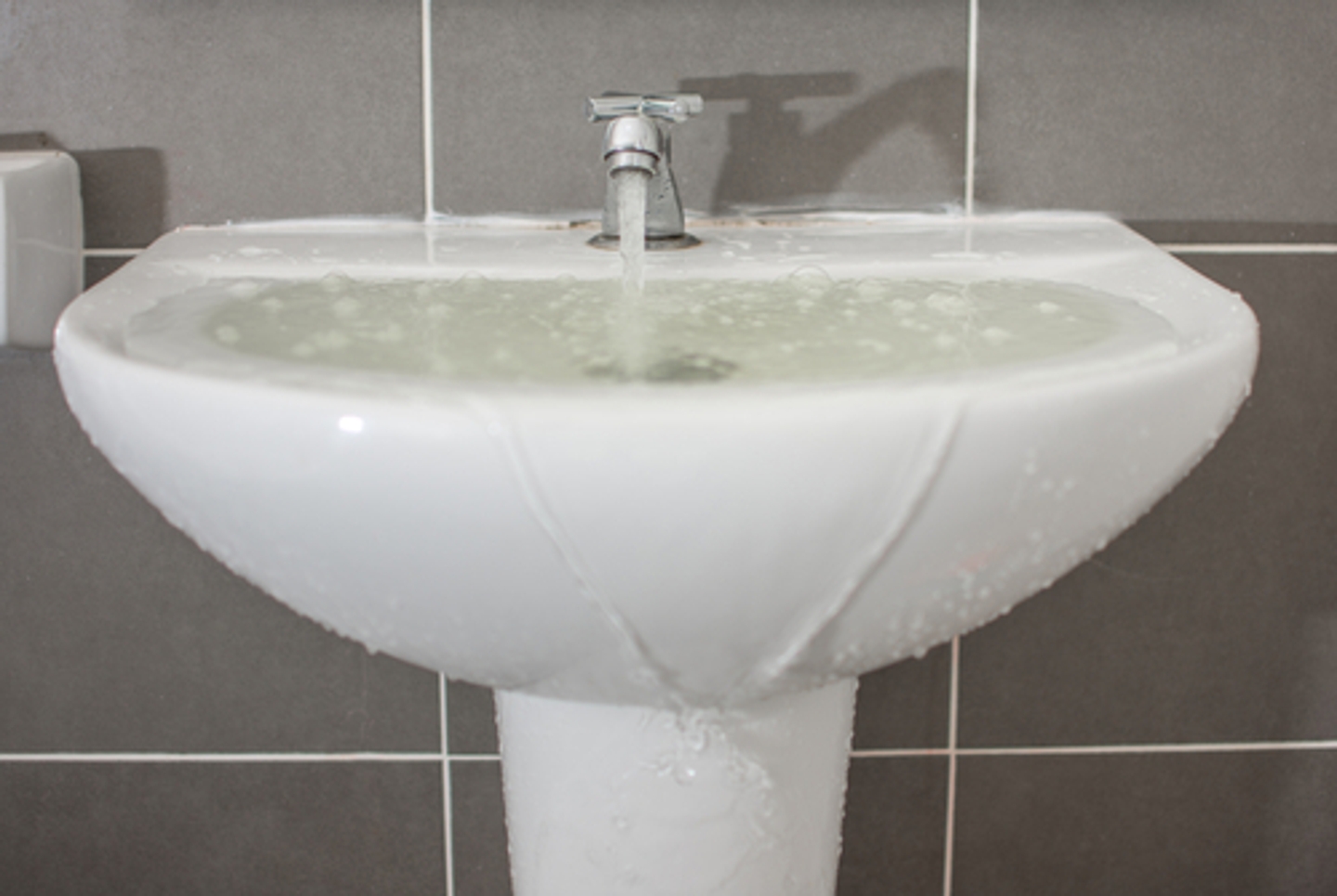 A sink overflowing with water in a bathroom. Insurance companies classify water damage into three categories. If you suffer category 1 water damage, category 2 water damage, or category 3 water damage, call SERVPRO. 