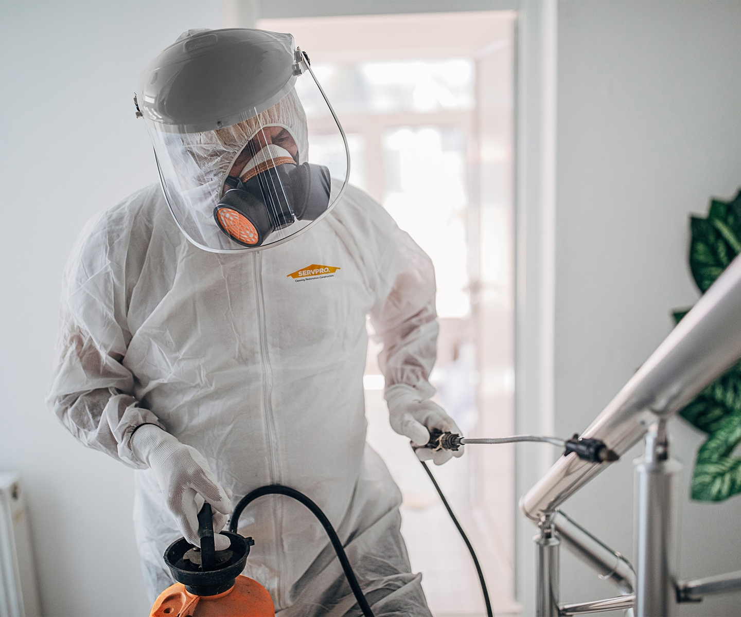 SERVPRO worker in hazmat suit cleaning up trauma scene