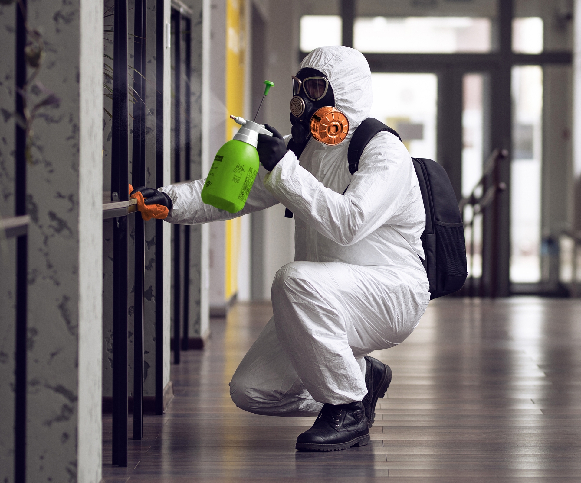 SERVPRO employee in hazmat suit cleaning mold in commercial building