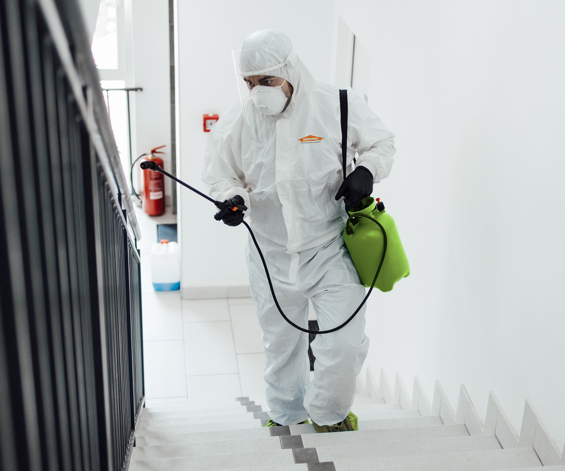 Worker in hazmat suit cleaning commercial space