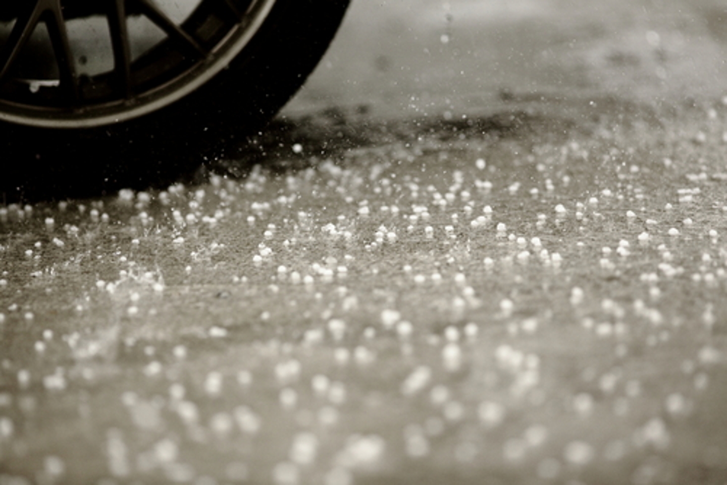 Hail falling by a car tire