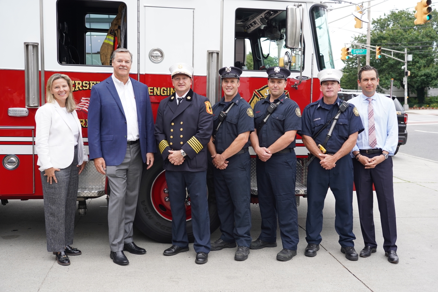 Group of people posing in front of firetruck