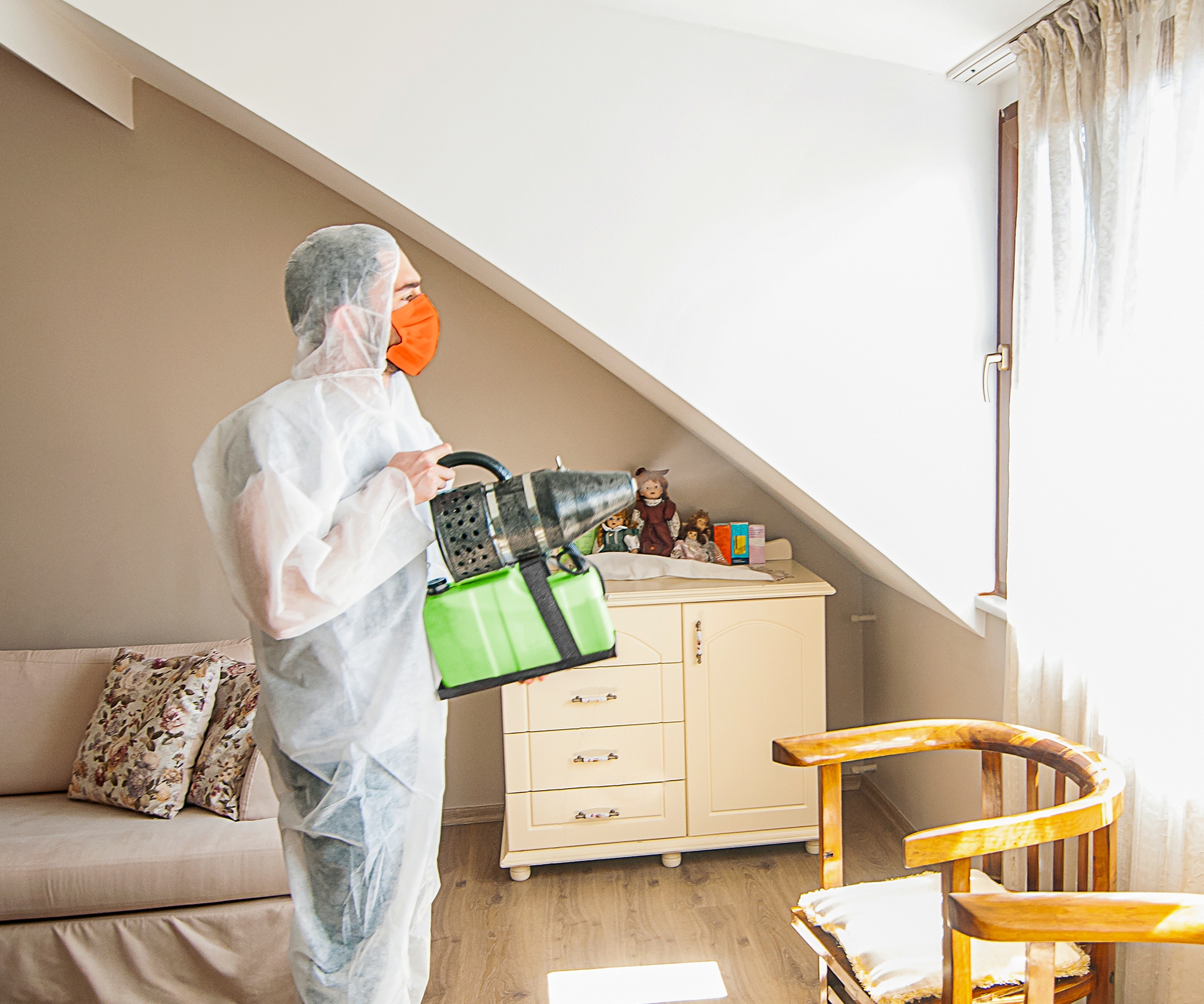 Person in hazmat suit spraying residential home