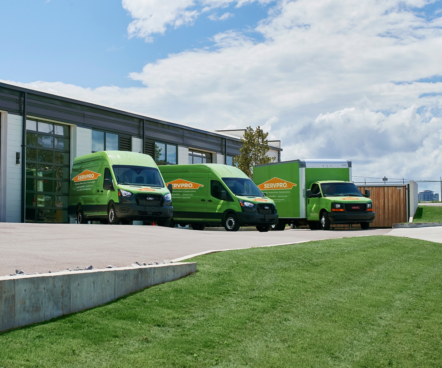 2 SERVPRO vans and a SERVPRO truck parked by a building waiting to serve your commercial business needs