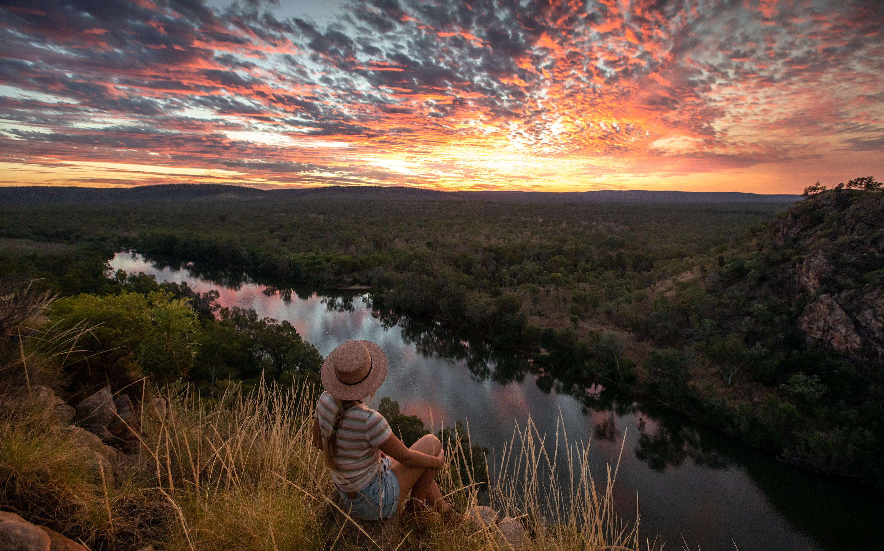 Girl watching the sunset from a hill over Nitmiluk National Park