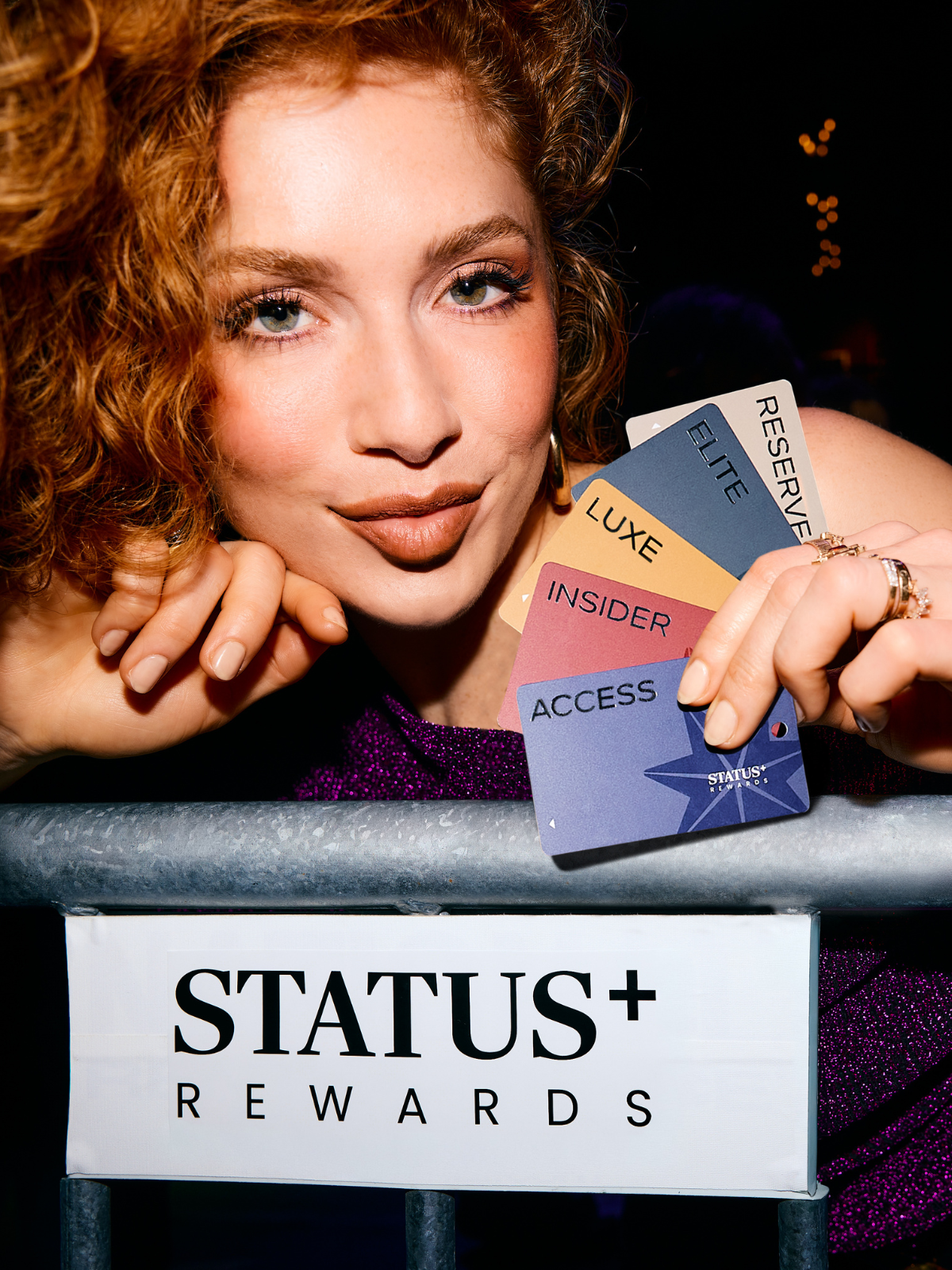 Woman holding Status+ Rewards Cards