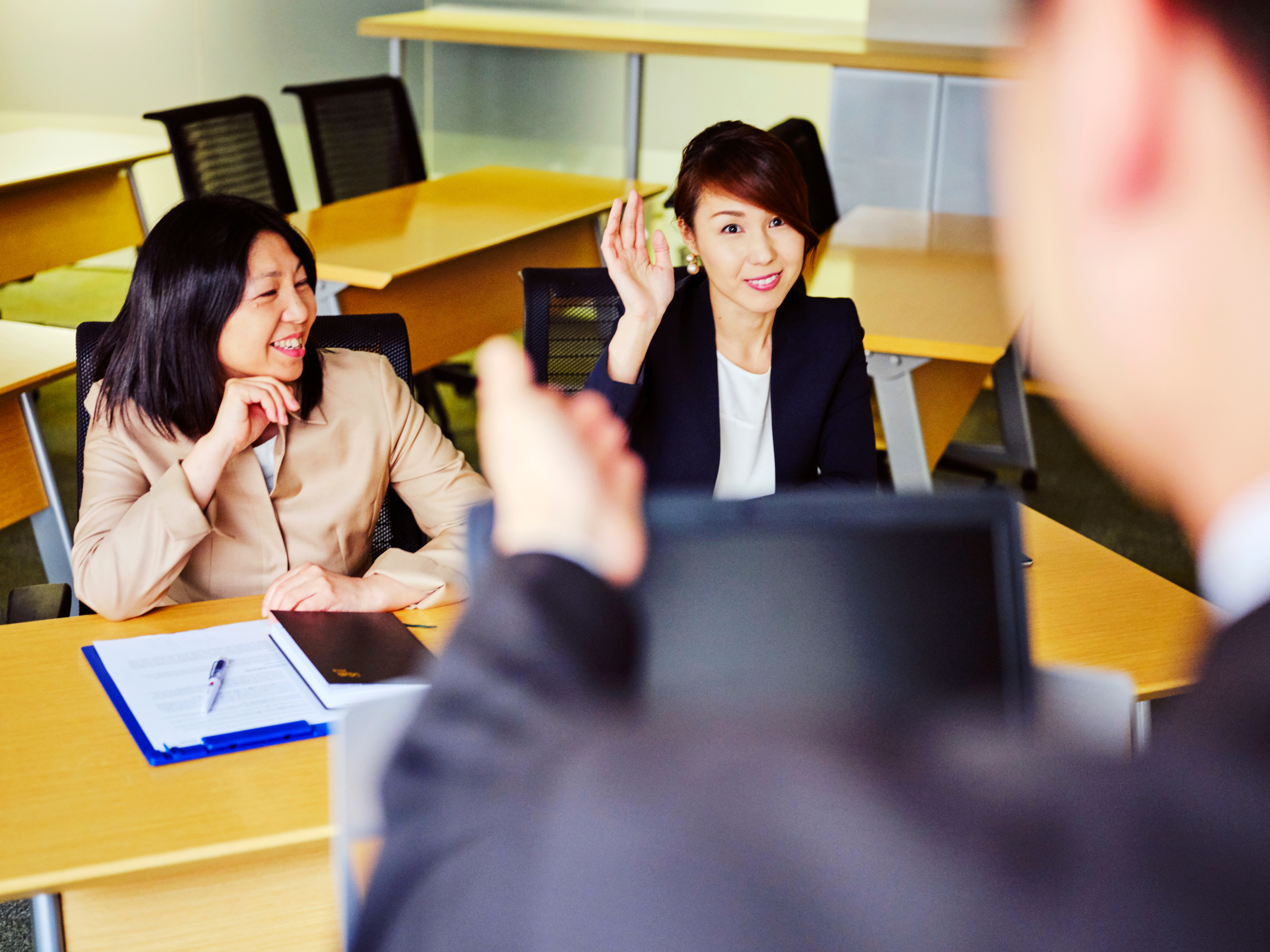 Dos mujeres en una reunión de trabajo formal.