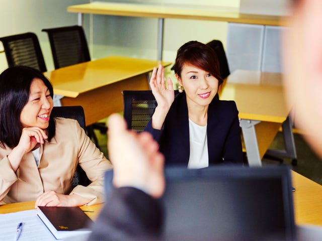 Dos mujeres en una reunión de trabajo formal.