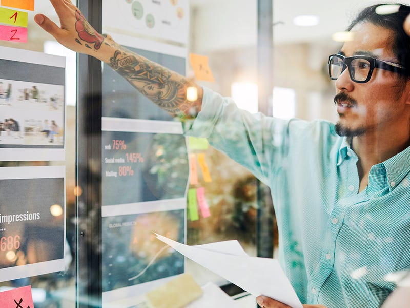 Hombre explicando un proyecto en su oficina a una compañera.