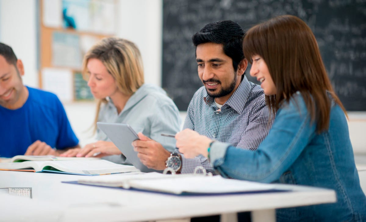 Grupo de personas aprendiendo en una clase de inglés, presencial y online en Perú