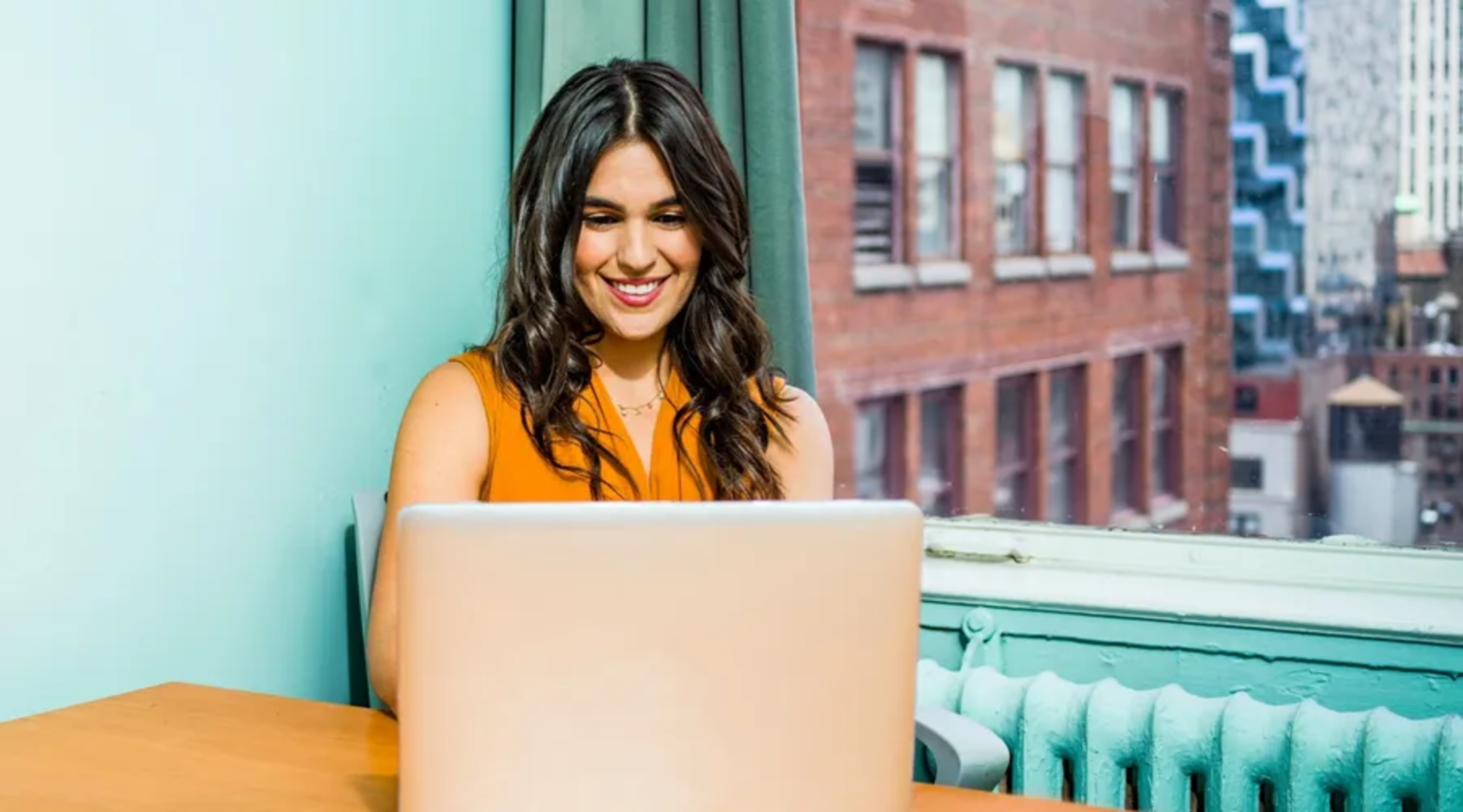 Persona feliz usando su laptop para aprender otro idioma desde Perú