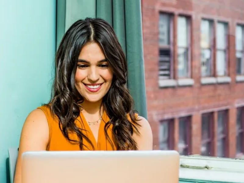 Persona feliz usando su laptop para aprender otro idioma desde Perú