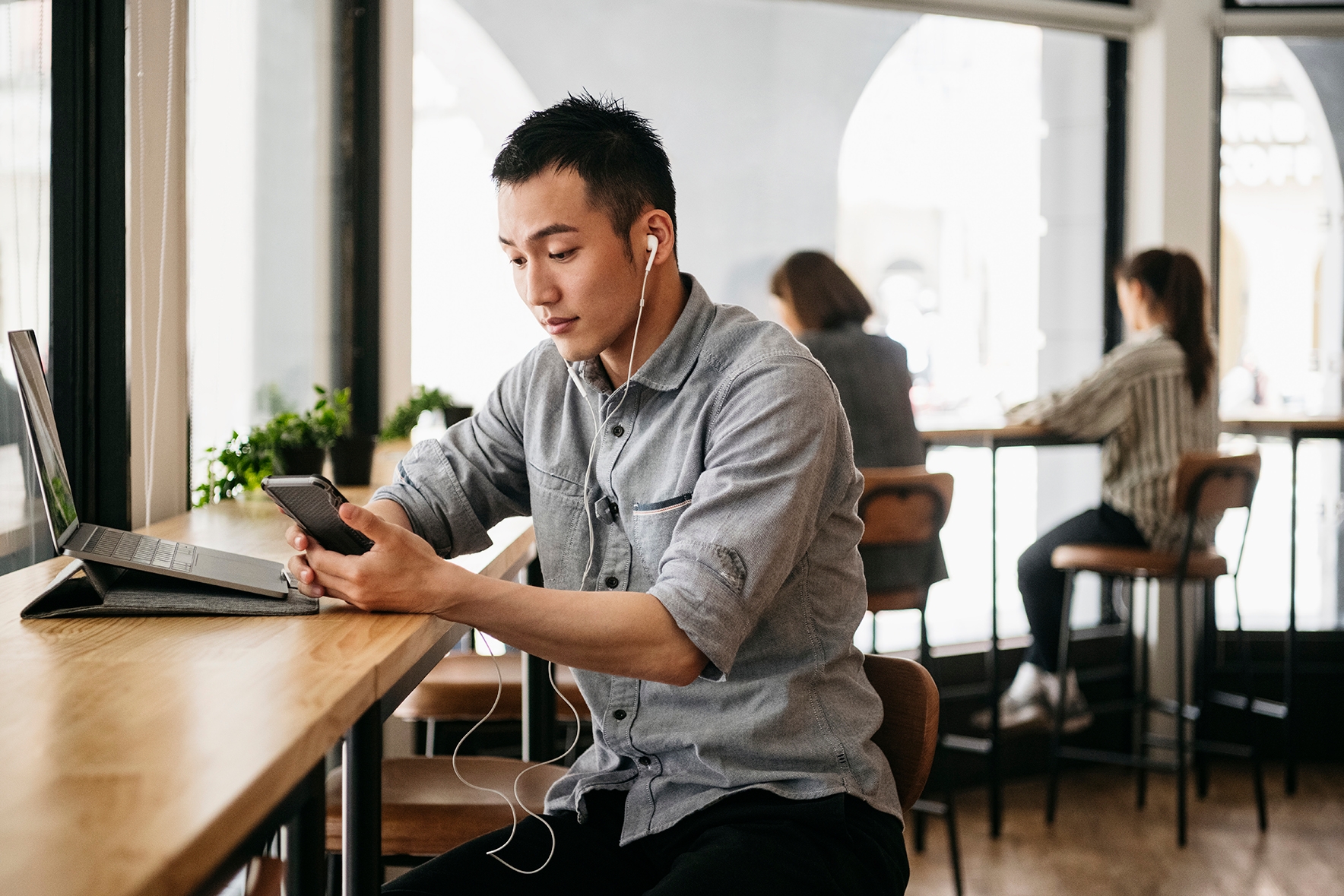 Joven en un café escuchando una clase online de inglés.