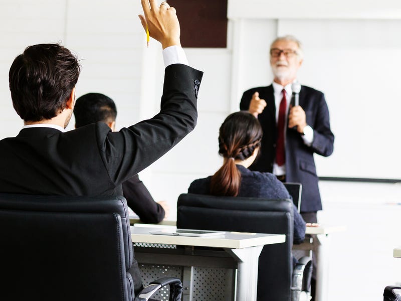 Hombre pidiendo hablar en una charla laboral.