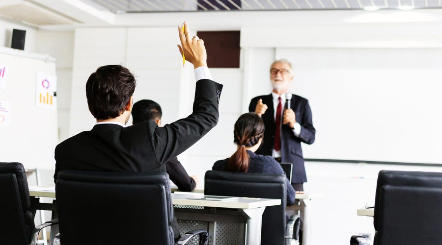 Hombre pidiendo hablar en una charla laboral.