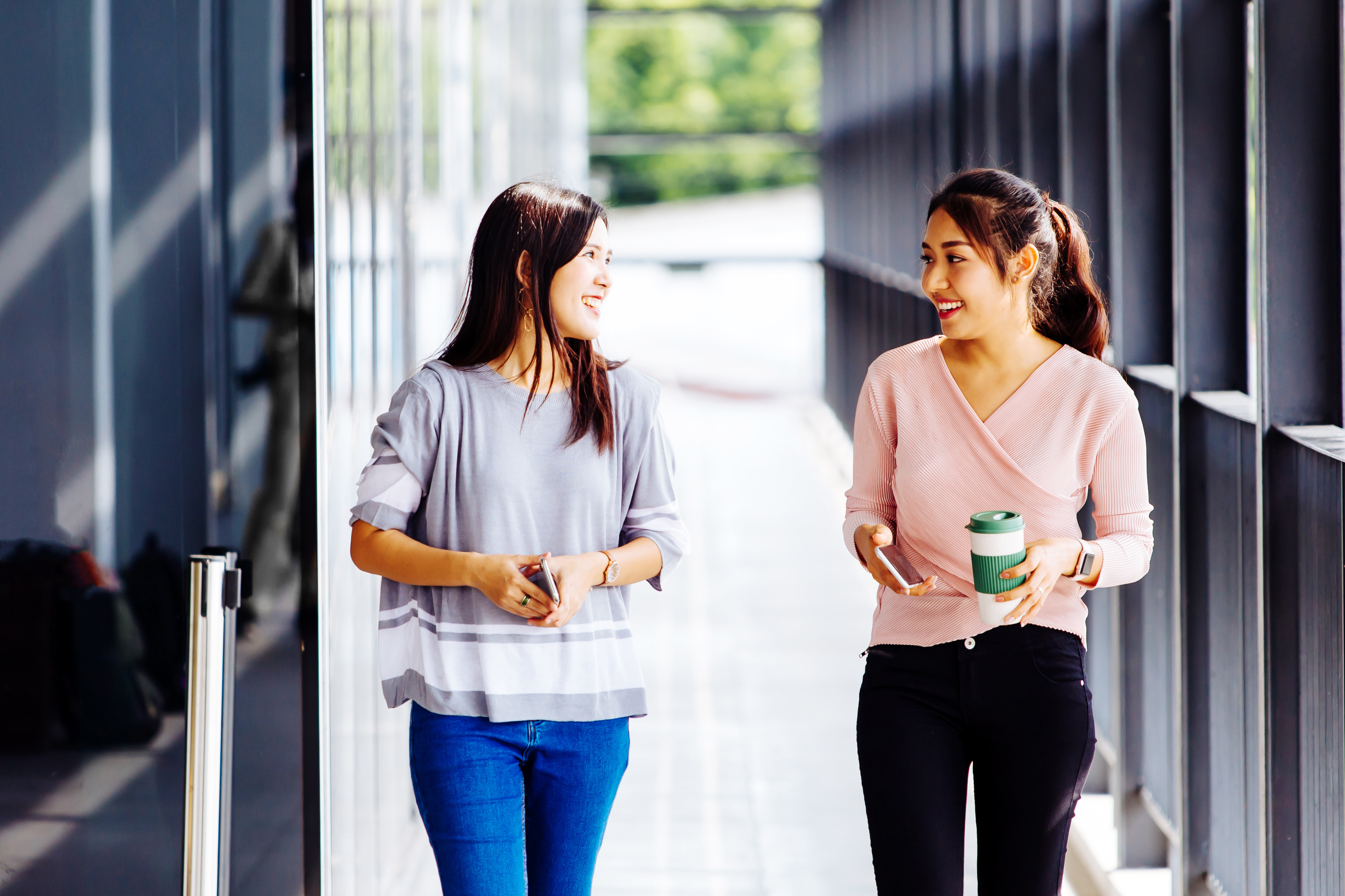 Dos mujeres jóvenes hablando inglés mientras caminan.