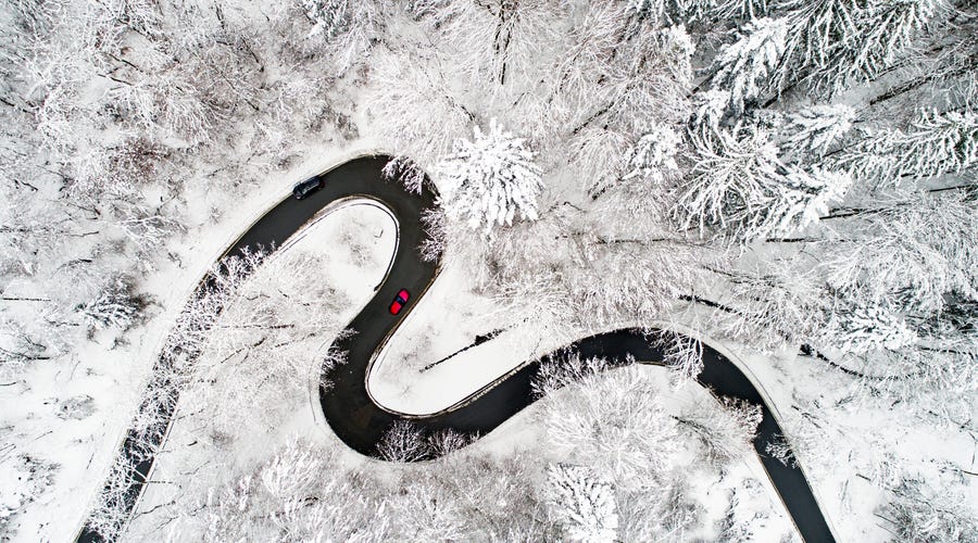 Camino sinuoso en un bosque en invierno.