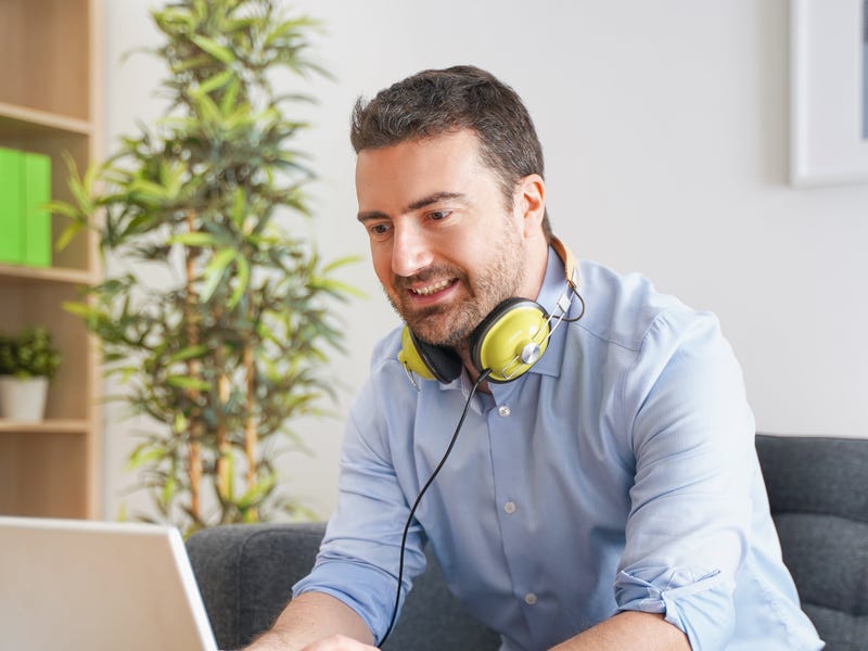 Hombre escribiendo en su computadora un saludo a sus compañeros.