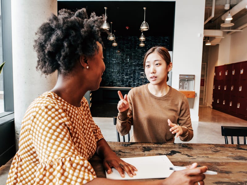Dos mujeres hablando en una universidad.