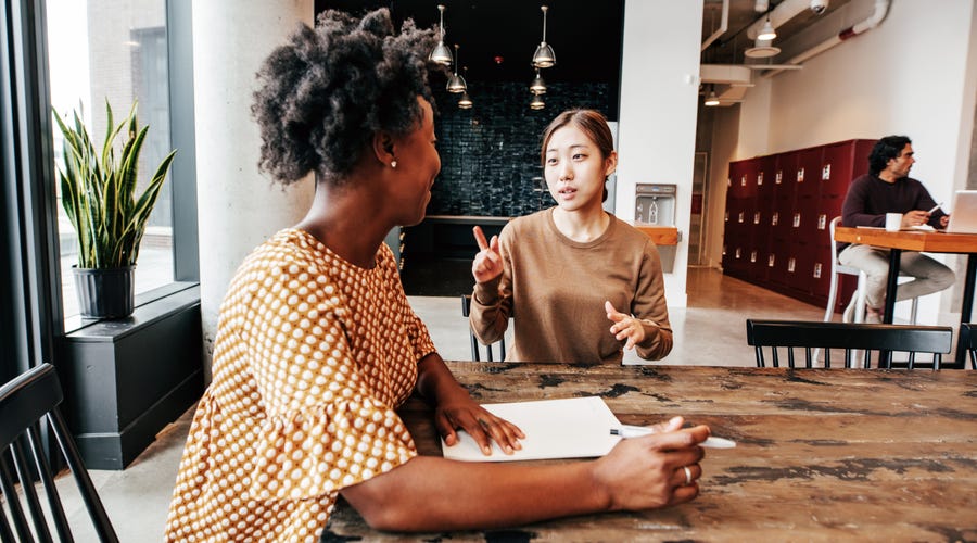 Dos mujeres hablando en una universidad.